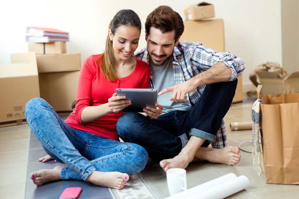 Portrait of Young couple with digital tablet in their new home